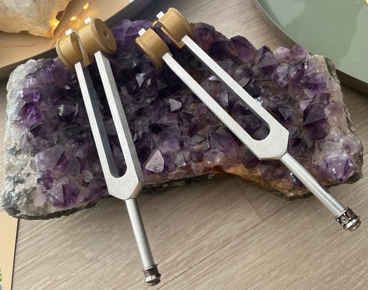 Acutonics planetary tuning forks resting on an amethyst crystal