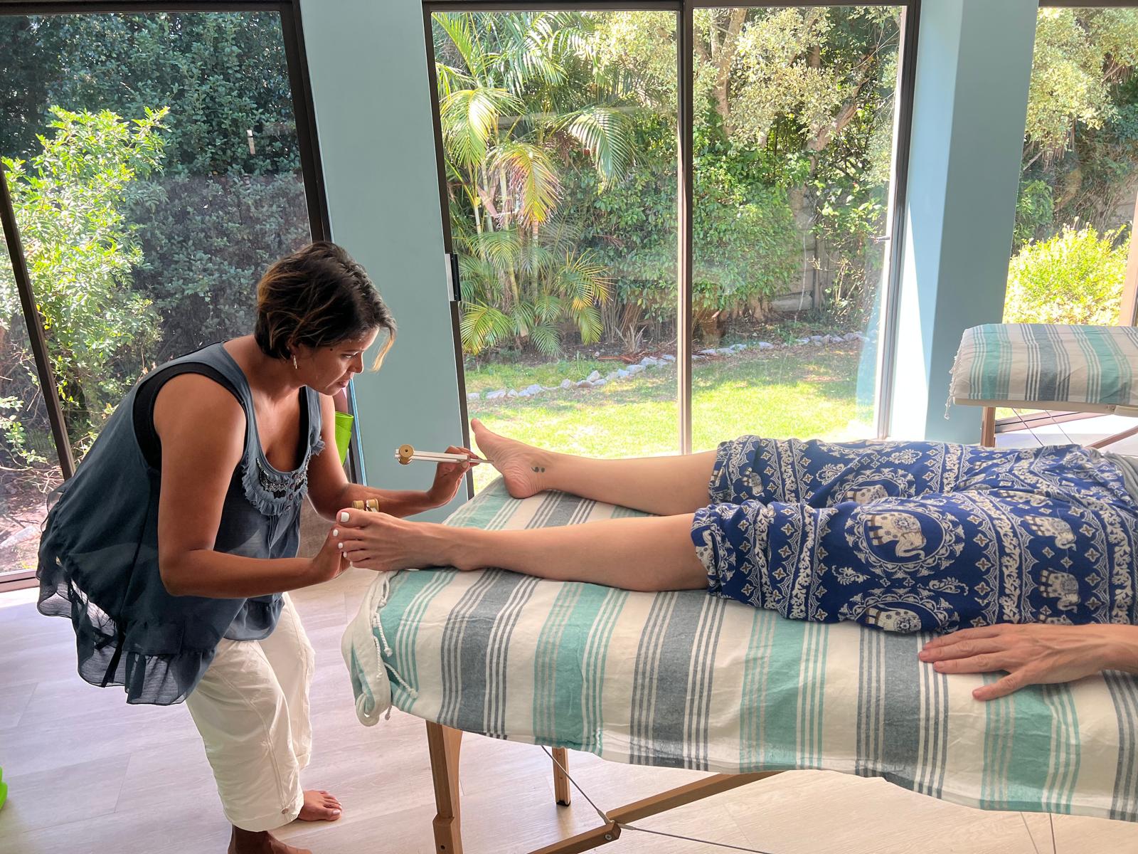 Acutonics practitioner working with tuning forks at the client's foot
