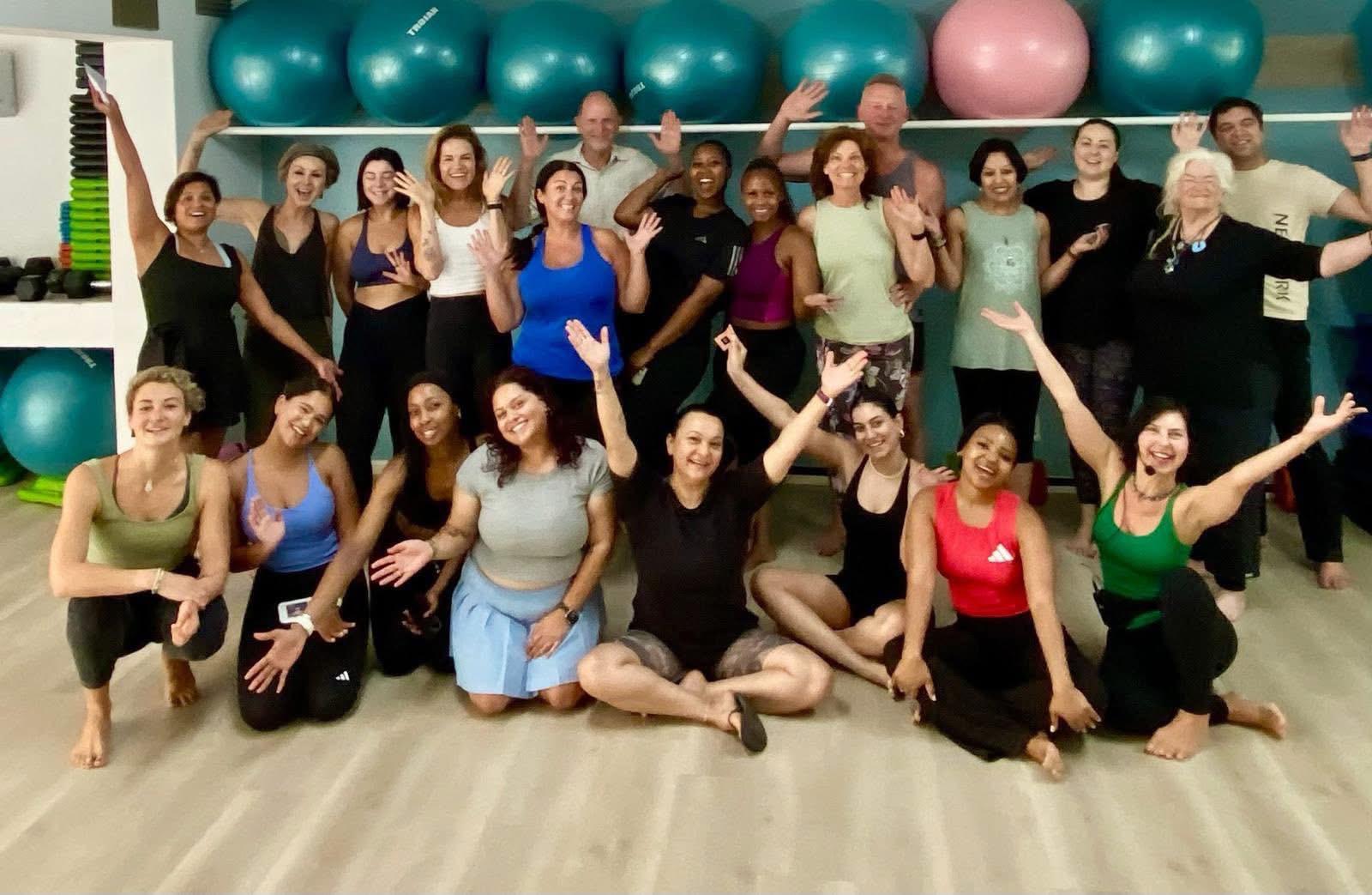 Joyful group photo of workshop participants celebrating together in the studio