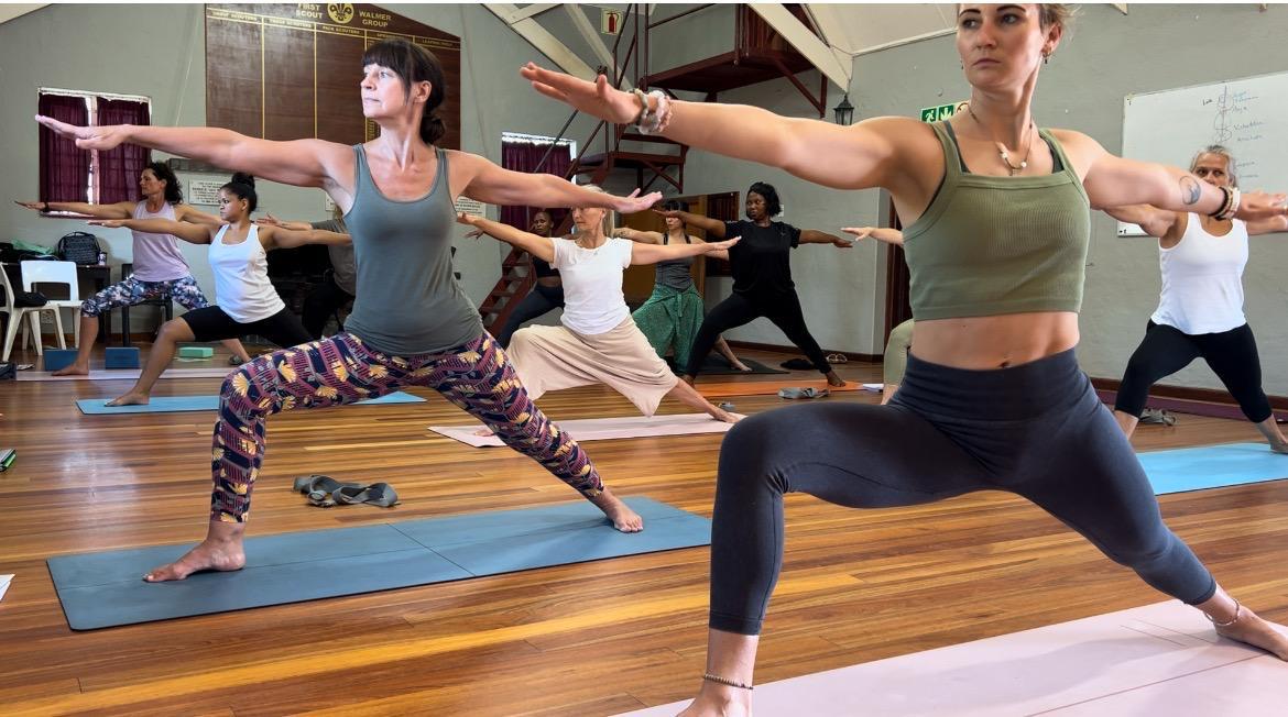 Warrior II pose practice during yoga workshop
