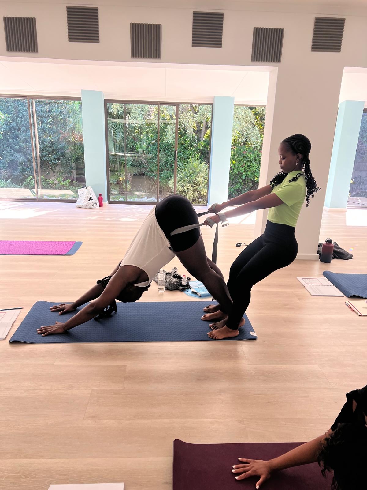 Trainee practising Downward Dog with a partner strap adjustment